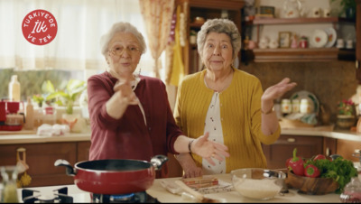 two women standing in a kitchen preparing food