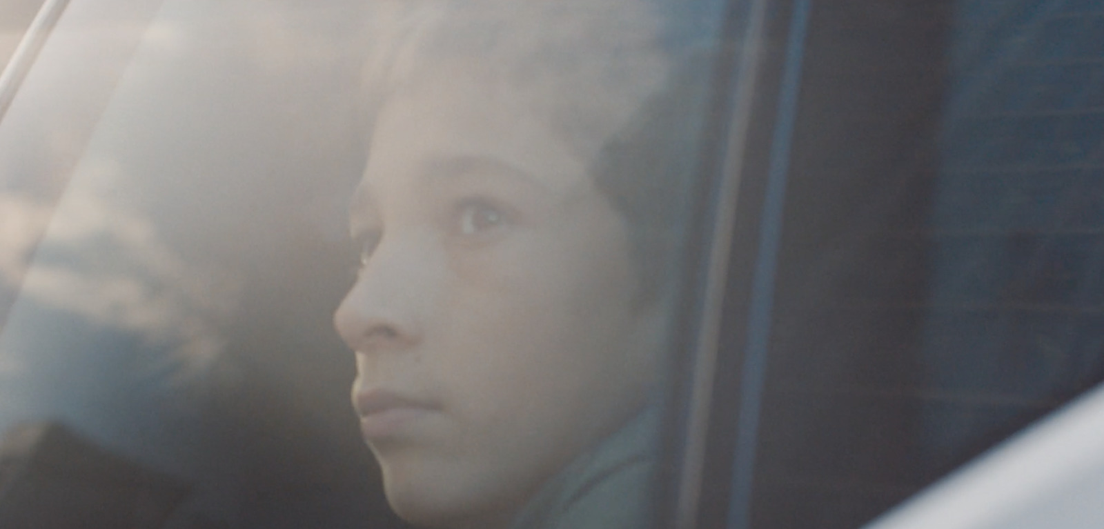 a woman sitting in a car looking out the window