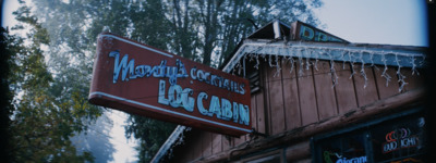 a sign for a restaurant hanging from the side of a building