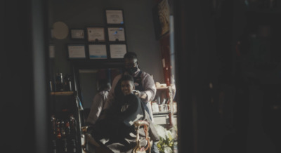 a man getting his hair cut in a barber shop