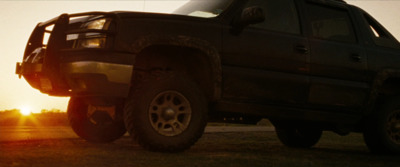 a truck parked on the side of a road at sunset