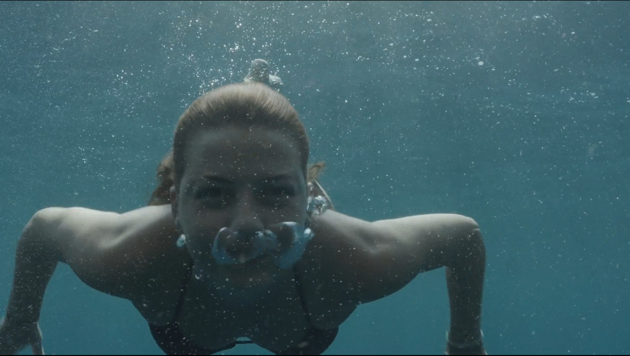 a woman swimming in the water with a mask on