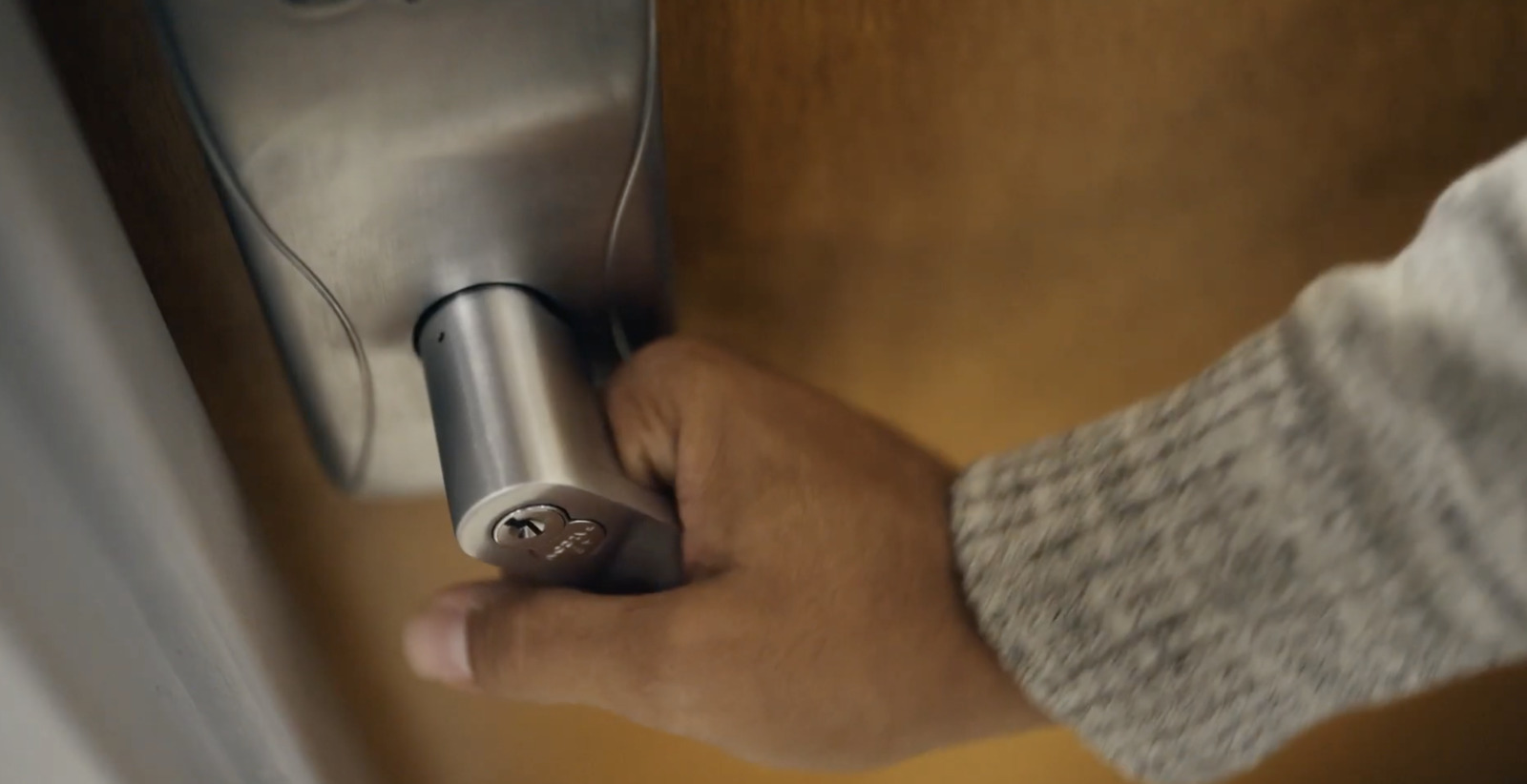 a person's hand holding onto a door handle