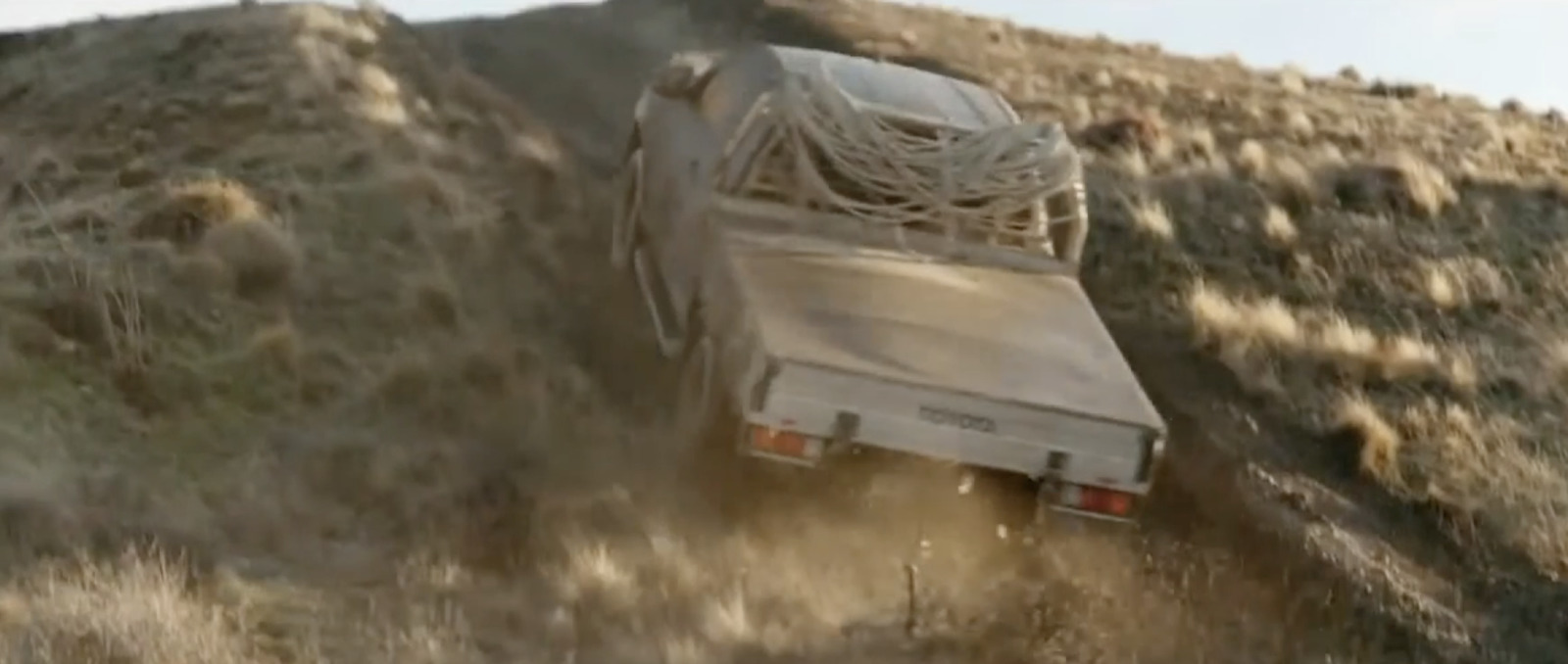 a truck is driving down a hill in the desert