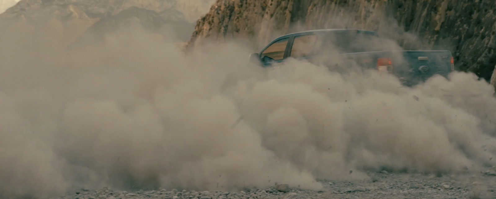 a car driving through a cloud of smoke