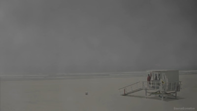 a lifeguard station on a beach with a cloudy sky