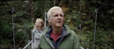 a man and a woman walking across a suspension bridge