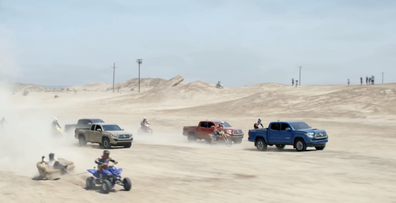 a group of people riding four wheelers on a dirt road