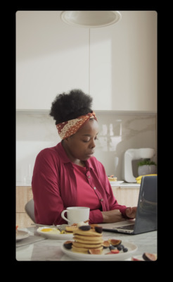 a woman sitting at a table using a laptop computer