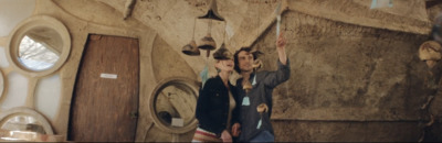 a man and a woman standing in front of a stone wall