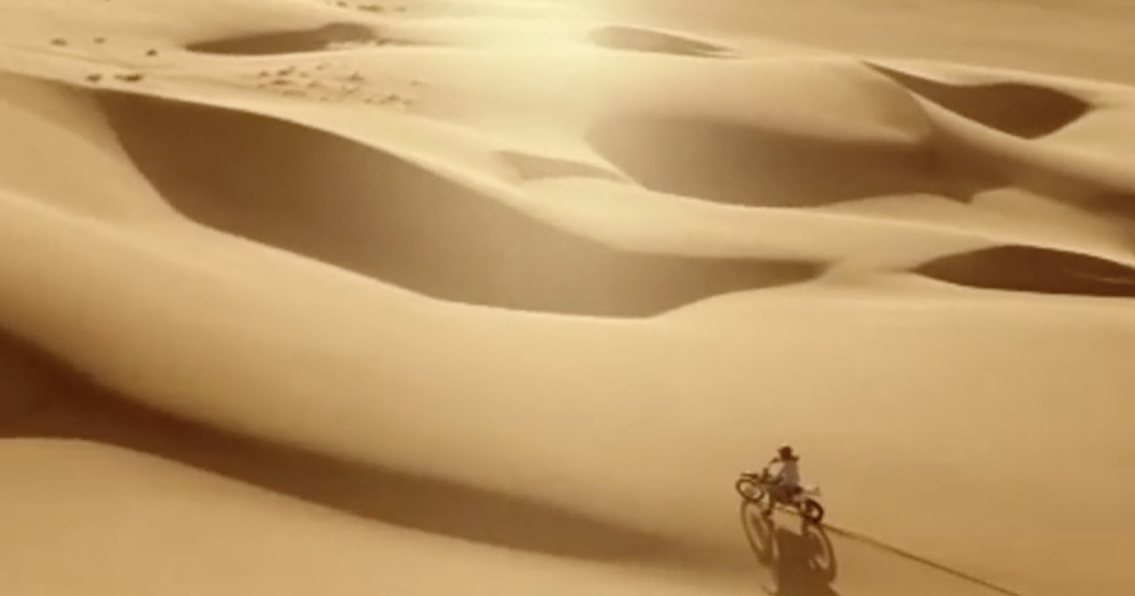 a person riding a bike in the desert