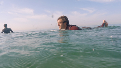 a man laying on a surfboard in the ocean