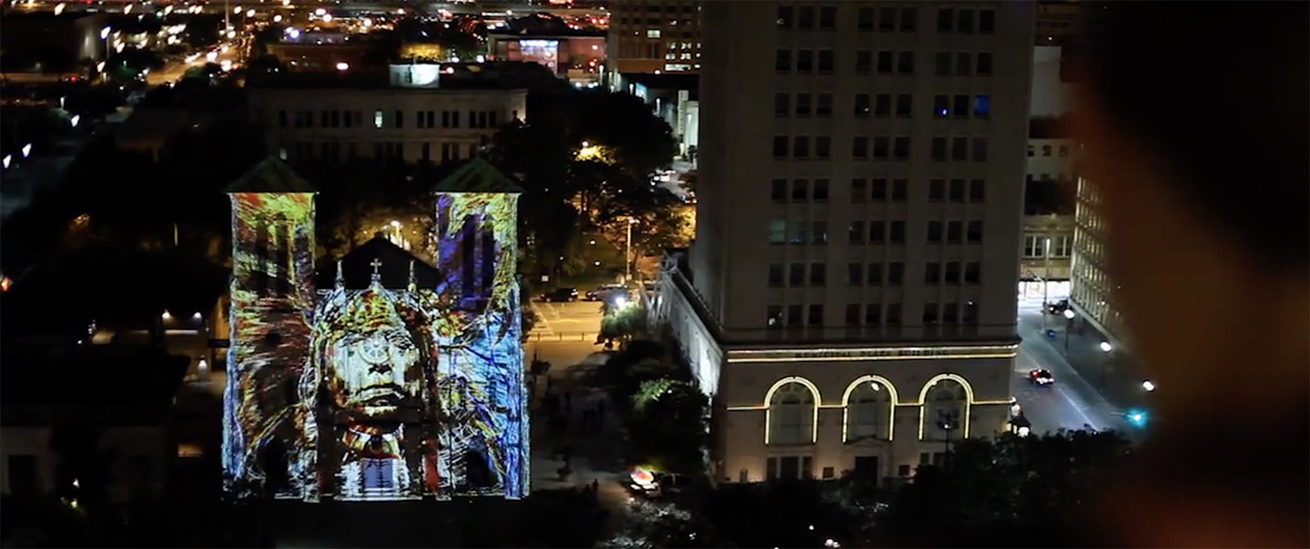 a very tall building with a giant projection on it's side