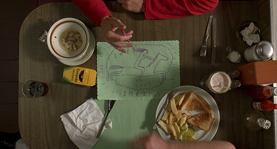 two people sitting at a table with a plate of food