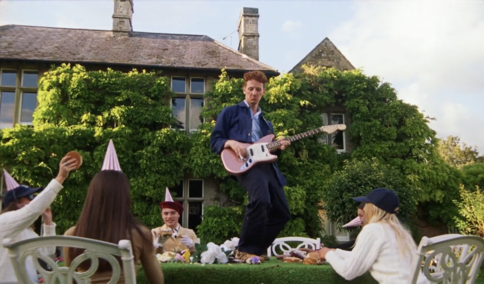 a man playing a guitar in front of a group of people