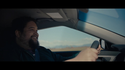 a man sitting in a car with a steering wheel