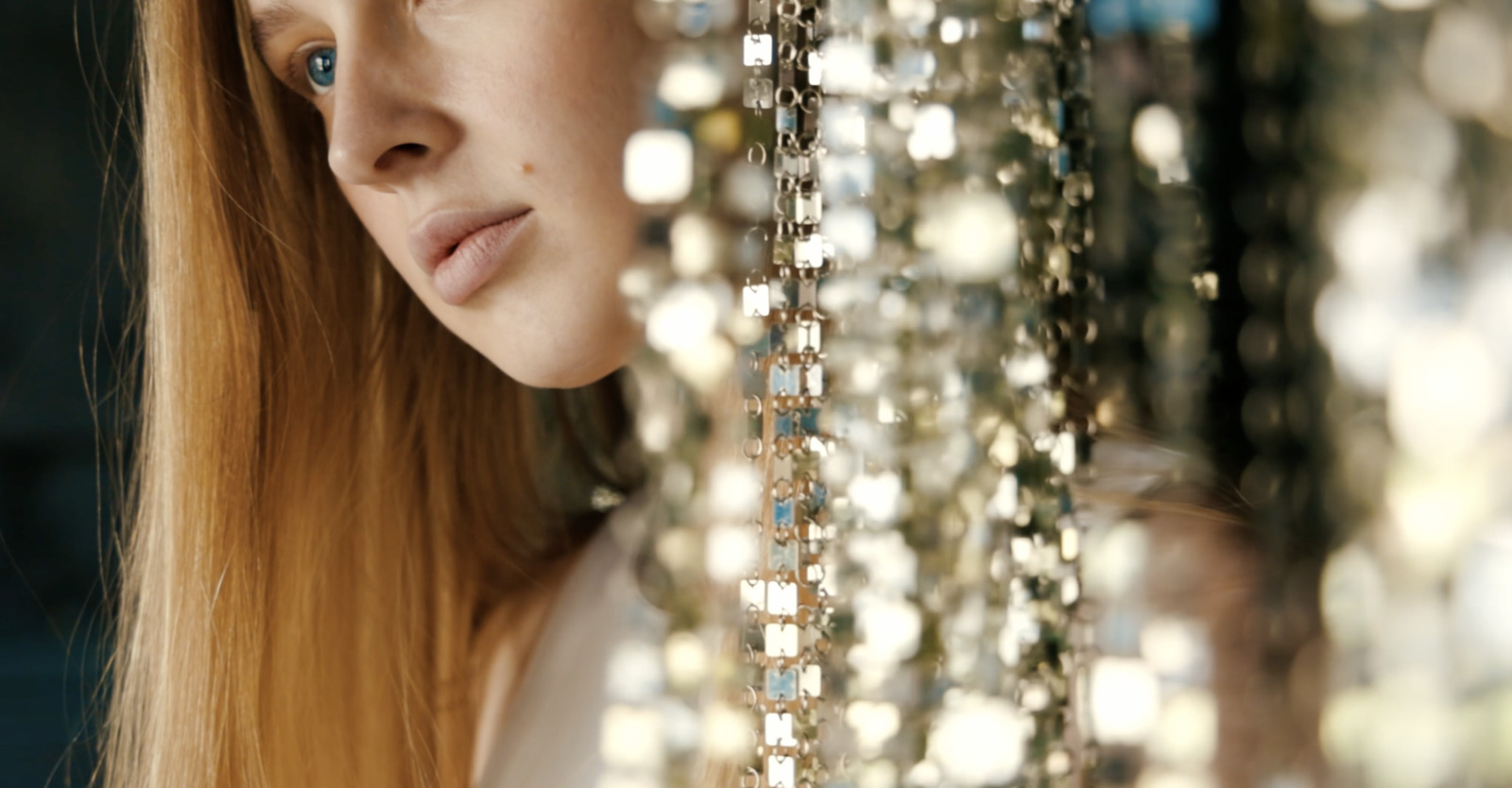 a woman with long red hair is looking at a bunch of beads