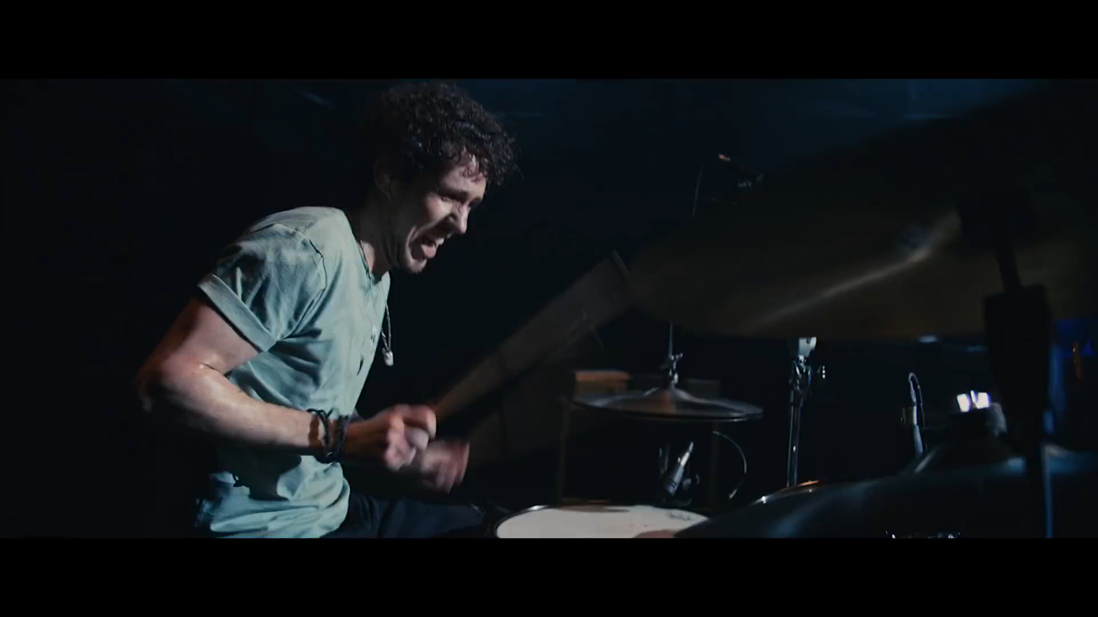 a man playing drums in a dark room