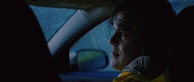 a man sitting in a car in the dark