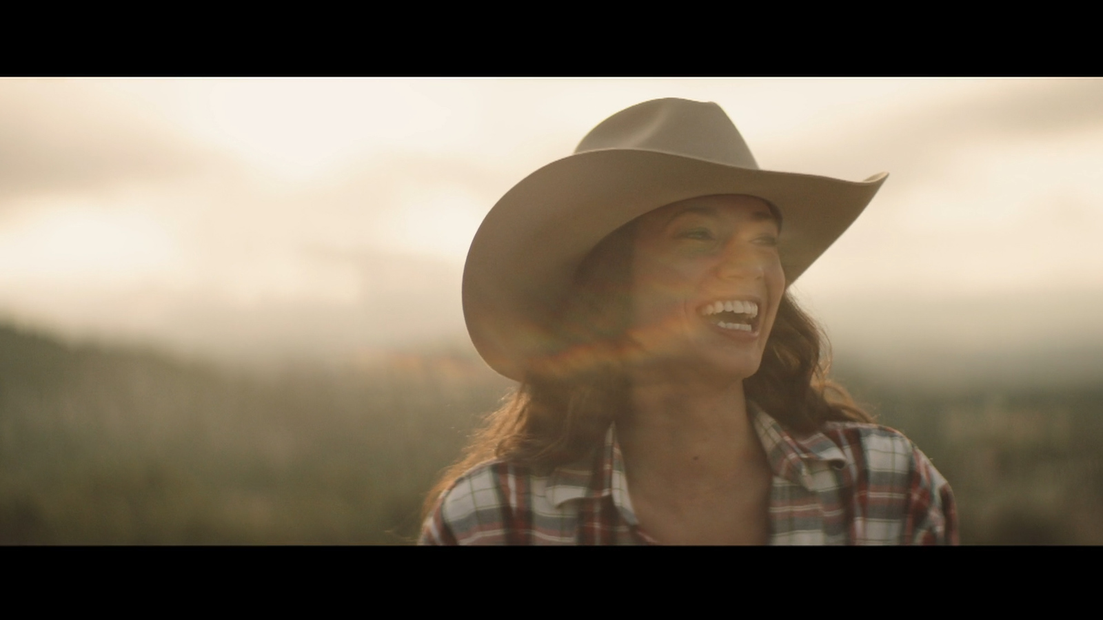 a woman wearing a cowboy hat in a field