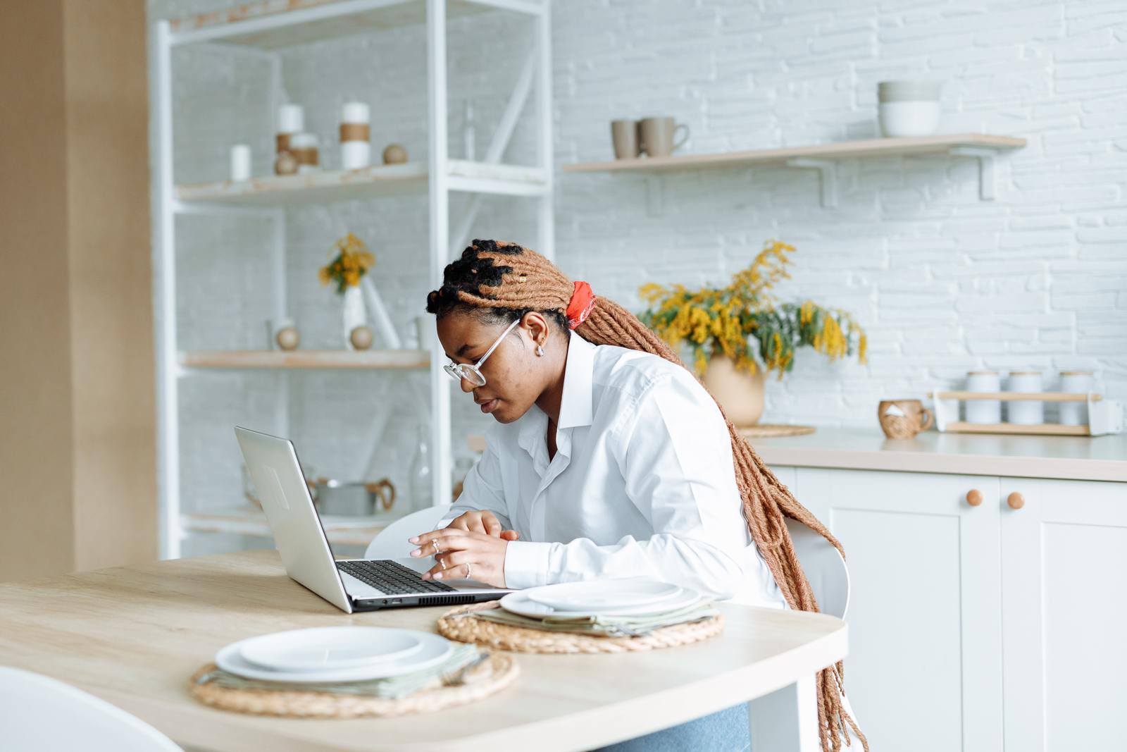 a woman sitting at a table using a laptop computer