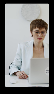 a woman sitting at a desk using a laptop computer