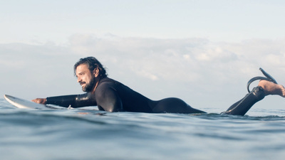 a man laying on a surfboard in the ocean