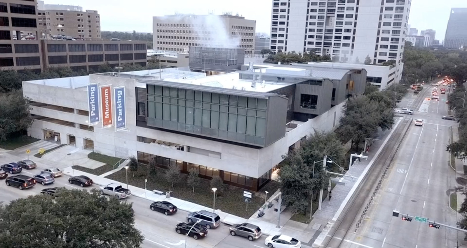 an aerial view of a building with cars parked in front of it