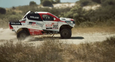 a red and white truck driving down a dirt road