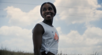 a woman standing in a field with a frisbee