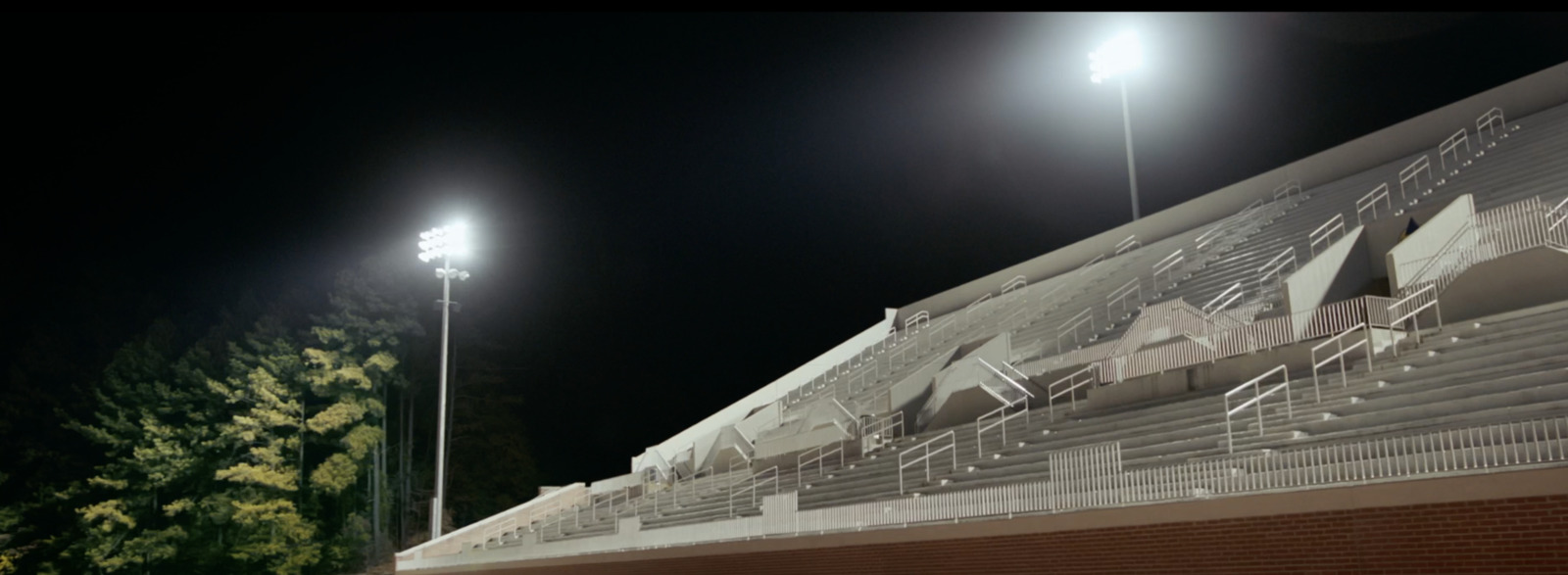 a stadium at night with lights on and empty bleachers