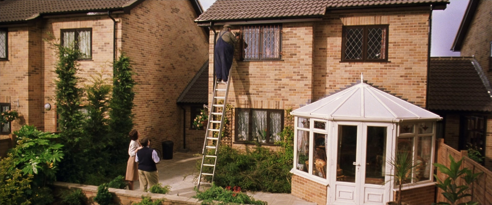 a couple of people that are standing outside of a house