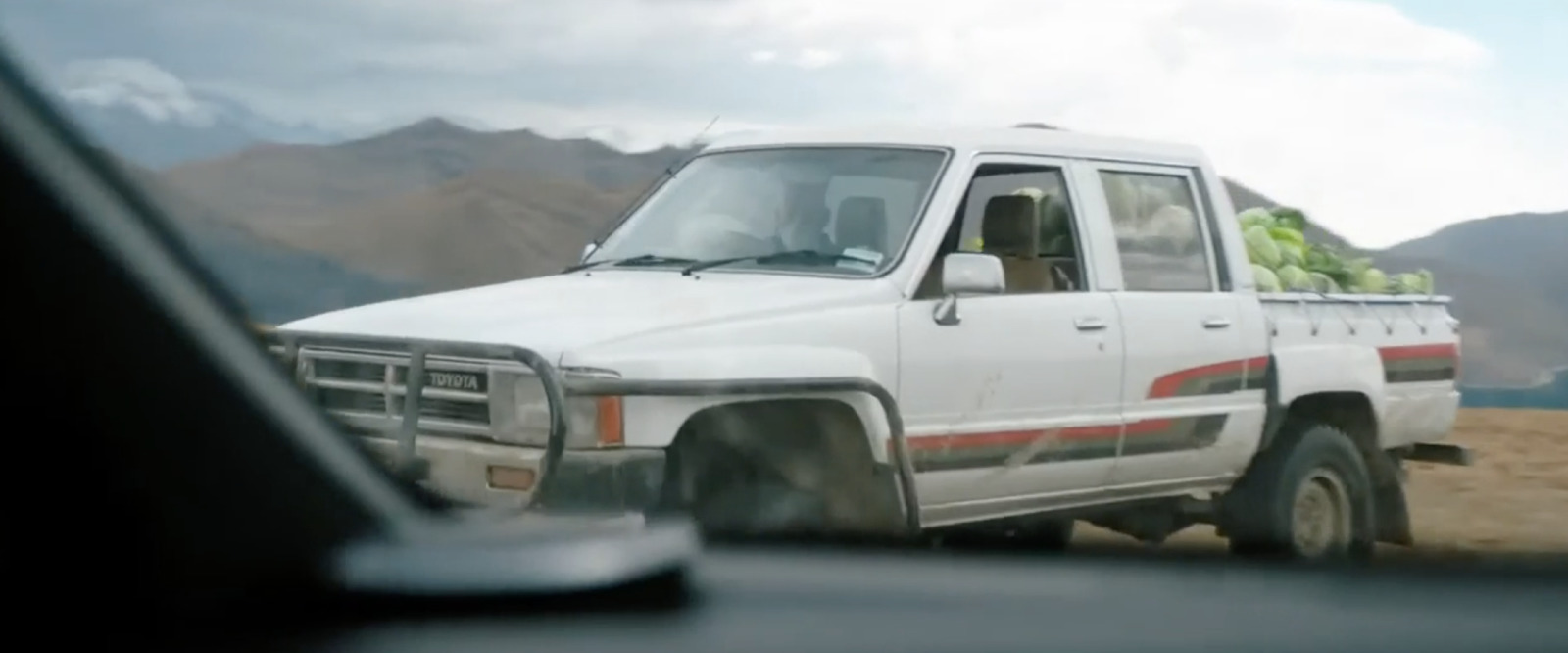 a white truck with a bunch of fruit on the back of it