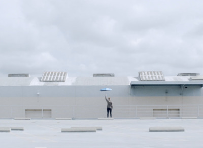 a person holding an umbrella in front of a building