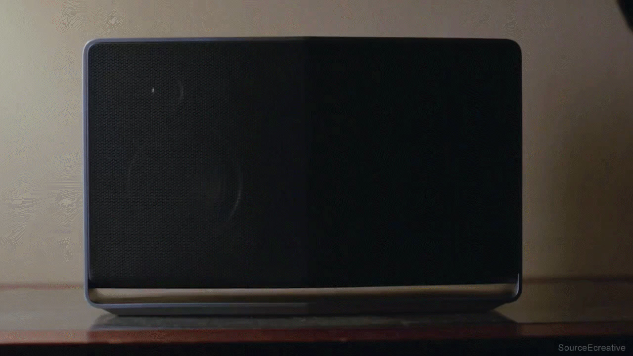 a black speaker sitting on top of a wooden table