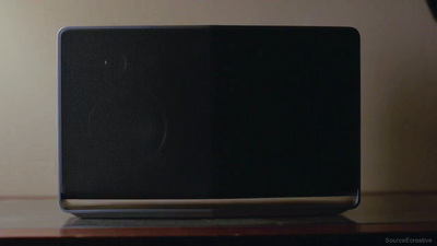 a black speaker sitting on top of a wooden table