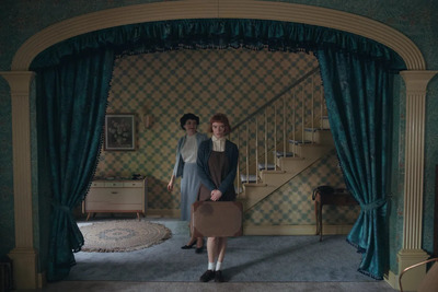 two women standing in front of a blue curtain