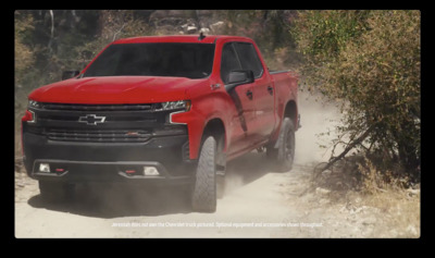 a red truck driving down a dirt road