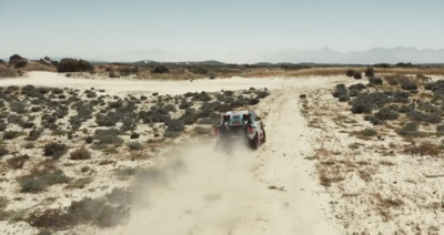 a car driving down a dirt road in the desert