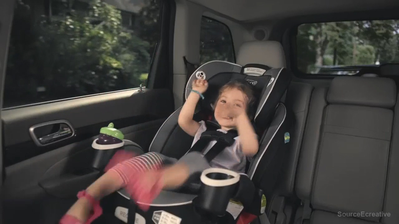 a little girl sitting in a car seat