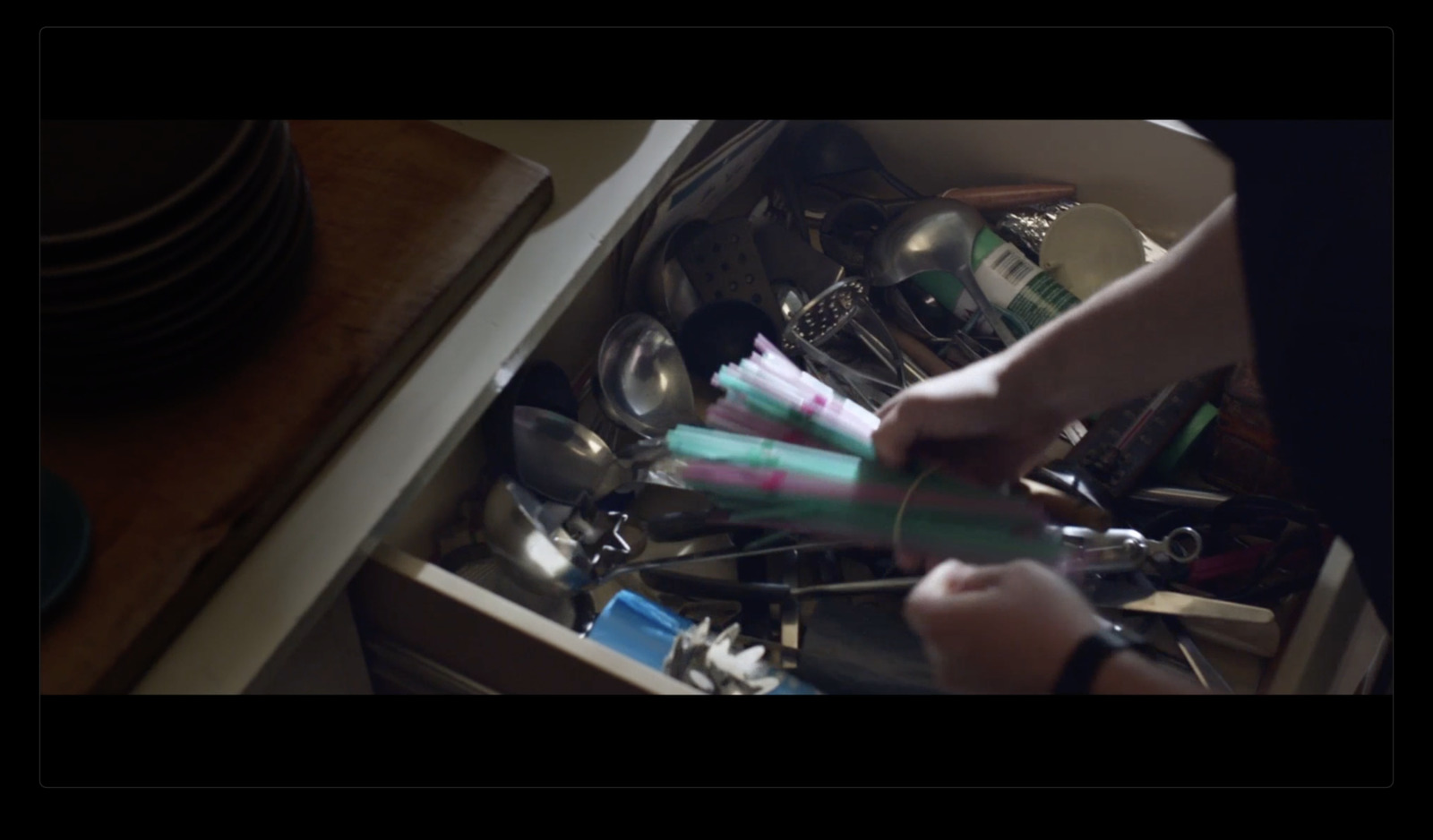 a person holding a toothbrush in a drawer full of dishes