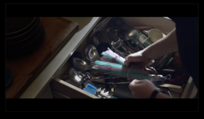 a person holding a toothbrush in a drawer full of dishes