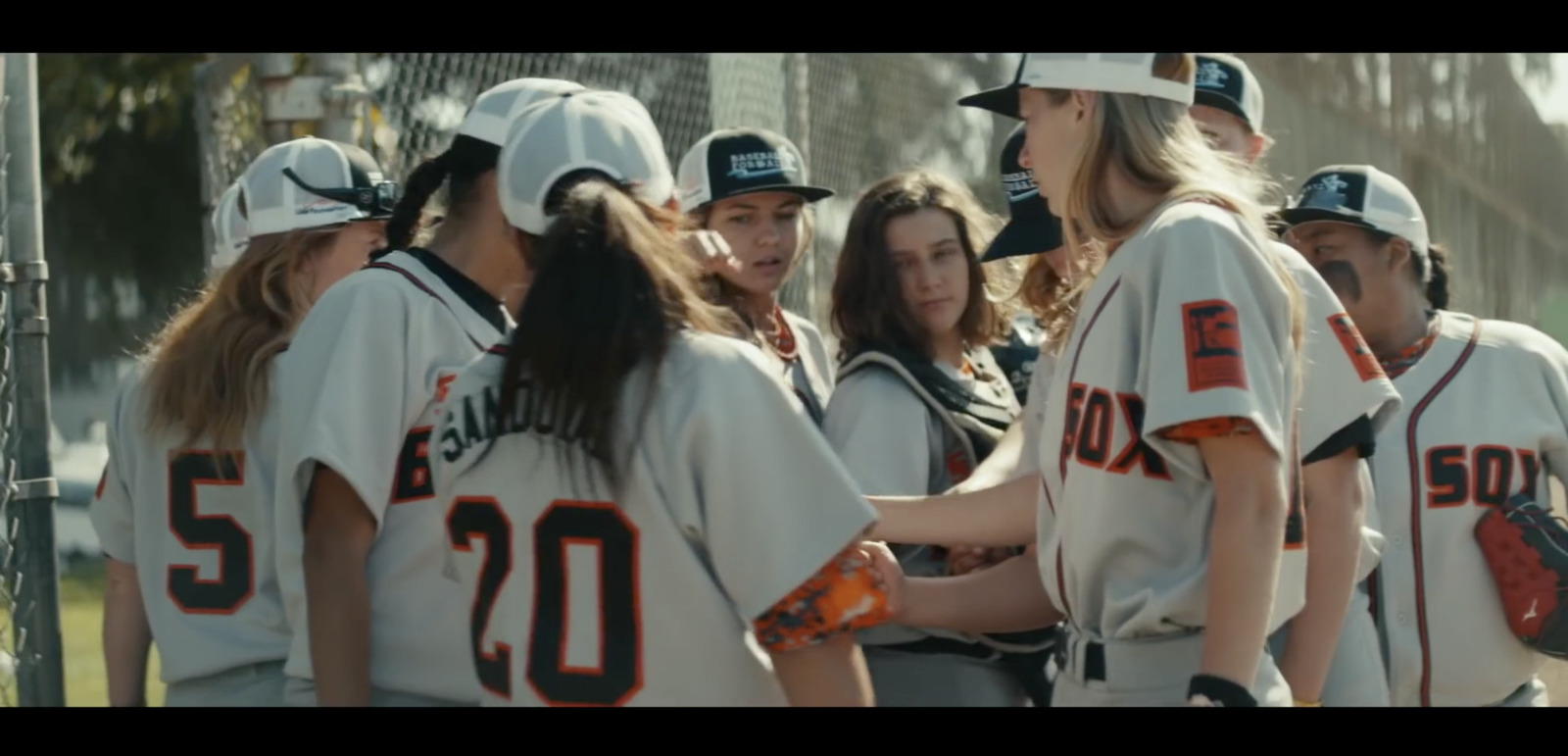 a group of women in baseball uniforms standing next to each other