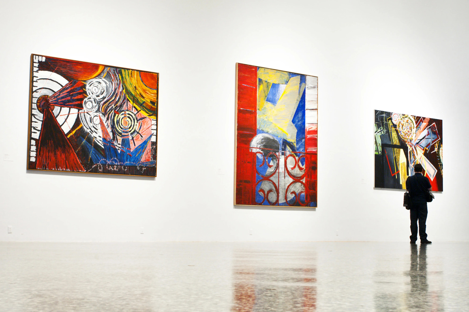 a man standing in front of paintings on a wall