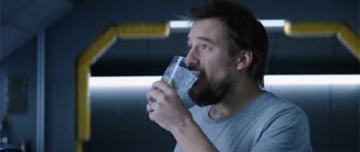 a man with a beard drinking from a glass