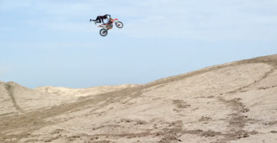 a man flying through the air while riding a motorcycle