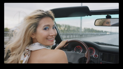 a woman sitting in a car with a steering wheel