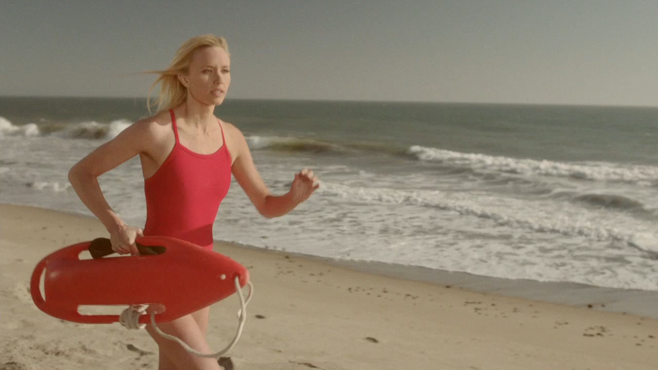 a woman in a red swimsuit running on the beach