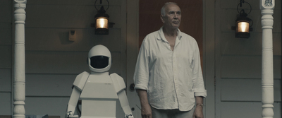 a man standing next to a robot on a porch