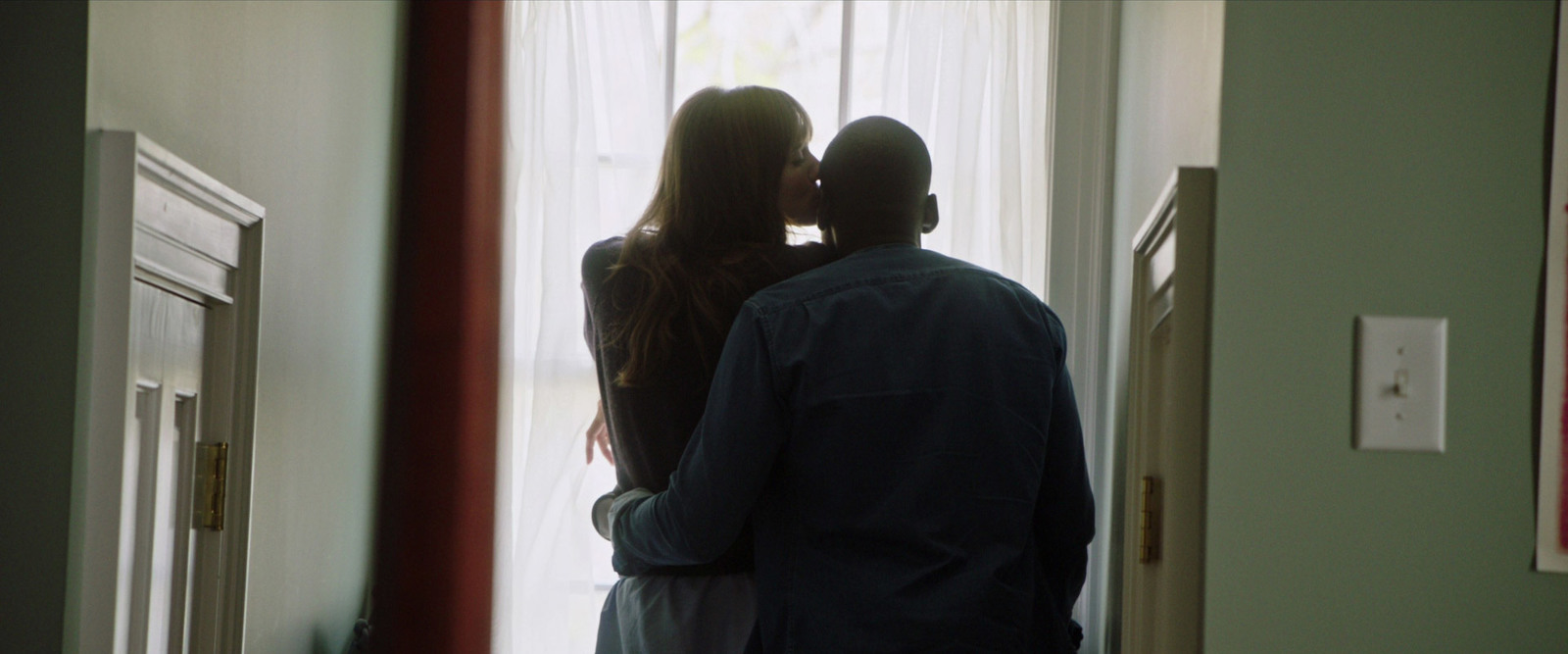 a man and a woman standing in front of a window